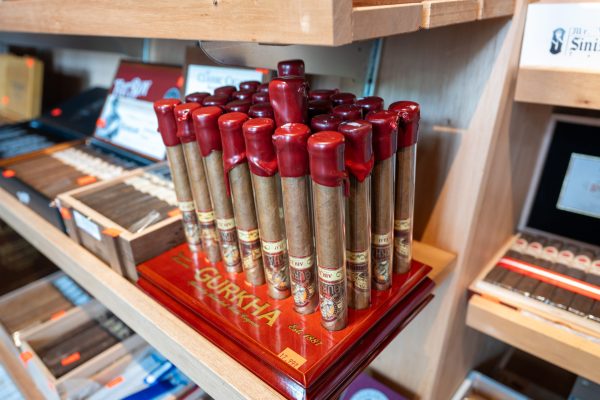 Bundle of Gurkha premium cigars with red foot caps on a polished wood plinth