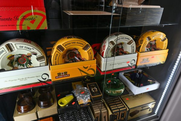Collectible Arturo Fuente ceramic ashtrays inside a glass display case