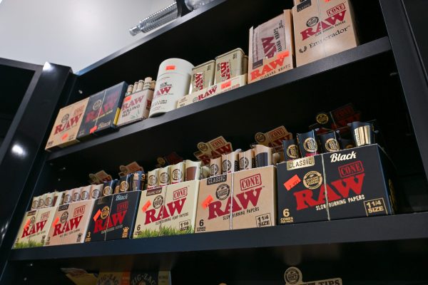 Stacked boxes of RAW rolling papers and cone packs on a retail shelf